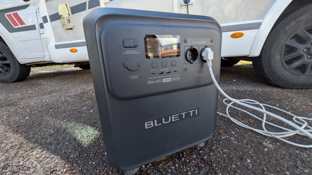 Batterie nomade Bluetti Elite 400 posée devant un camping-car