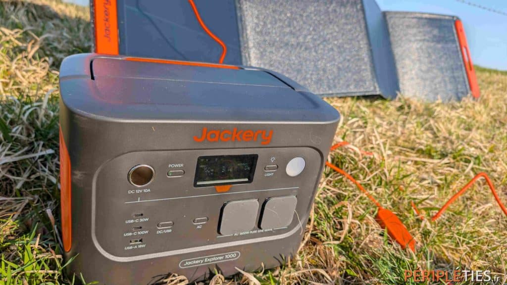 Jackery Explorer 1000 V2 posée dans l'herbe devant ses panneaux solaires