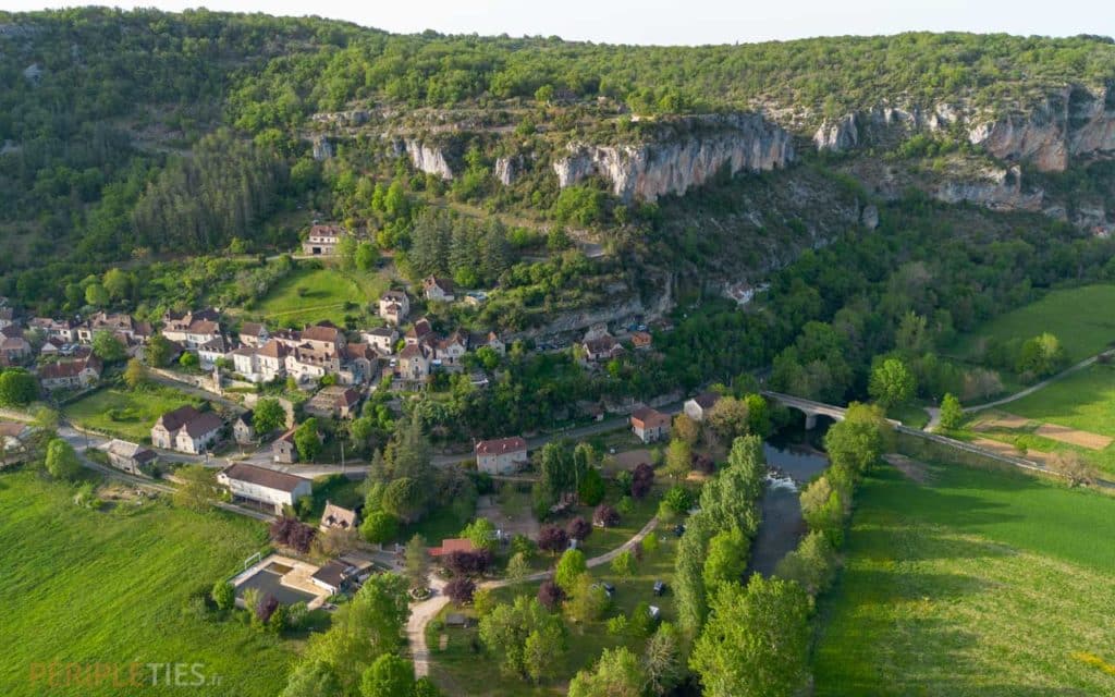 Vue aérienne du village de Saint-Sulpice-sur-Célé entouré de falaises dans le Lot