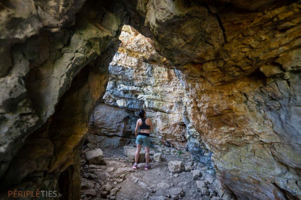 Randonneuse dans une cavité rocheuse de la vallée du Célé dans le Lot