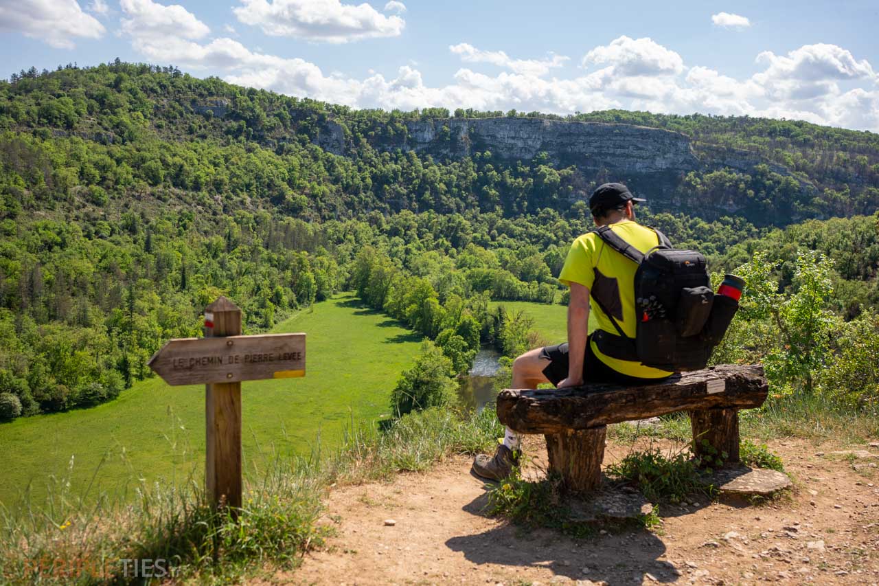 Randonneur assis face à la vallée du Célé lors d’une randonnée à Sauliac-sur-Célé