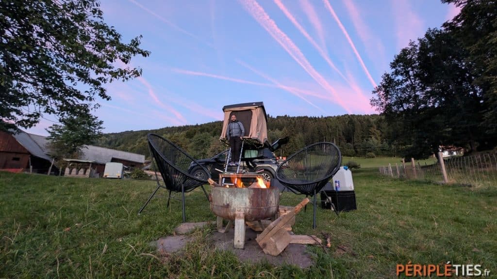 Feu de camp devant une tente de toit lors d'une étape à la ferme